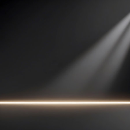 A dark stage floor is illuminated by a focused spotlight beam originating from the upper right, casting soft rays. A thin, horizontal line of warm light runs along the bottom edge of the frame, suggesting a stage boundary or accent. The scene is minimalist and atmospheric, ideal for presentations or event backdrops.の素材
