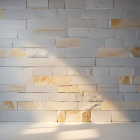 This image presents a wall constructed from a combination of smooth white panels and textured beige stone blocks. Natural light streams in from the side, casting dappled shadows and creating a sense of depth and dimension across the textured surfaces. The interplay of light and shadow adds a dynamic and organic feel to the otherwise geometric arrangement of the materials.の素材