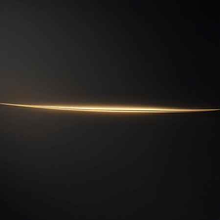 A very thin, horizontal line of bright golden light stretches across a deep, dark background. The light has a soft glow and appears to be slightly diffused, creating a subtle yet distinct illumination. The composition is minimalist and clean, with the light line serving as the sole focal point against the dark expanse.の素材
