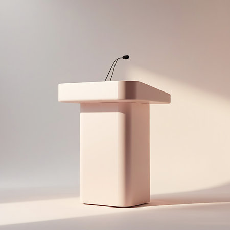 A minimalist podium with a sleek design stands on a light-colored surface. A thin microphone is attached to the top of the podium, angled slightly forward. Soft, warm lighting casts gentle shadows on the background, creating a serene and uncluttered atmosphere. The overall aesthetic is clean and modern, suitable for presentations or speeches.の素材