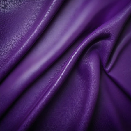 Vibrant purple faux leather fabric with smooth, shiny surfaces and soft folds creating subtle shadows and highlights.の素材