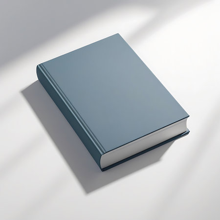 A closed blue hardcover book rests on a white surface, casting soft shadows from overhead light. Clear details and vibrant colors enhance visual appeal.の素材