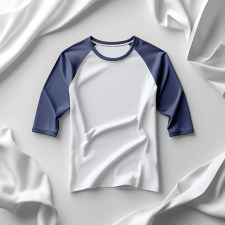 A white baseball t-shirt with navy blue 3/4 raglan sleeves is artfully arranged with flowing white fabric on a light gray background.の素材