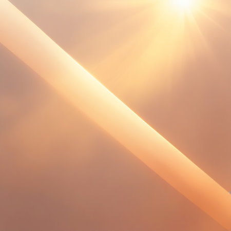 A diagonal light beam with a sunburst effect shines across a warm peach background, suggesting a bright and radiant light source.の素材