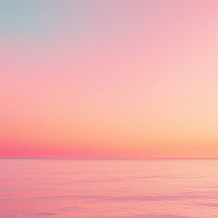 This image captures a serene sunset over the ocean. The sky transitions beautifully from soft pinks and oranges near the horizon to light blues higher up. The calm water reflects the vibrant colors, creating a peaceful and tranquil scene. The horizon is clearly visible, separating the sky from the sea with a thin, distinct line.の素材