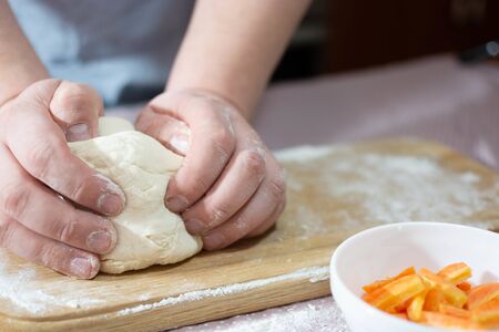 Knead the dough on a wooden board at home