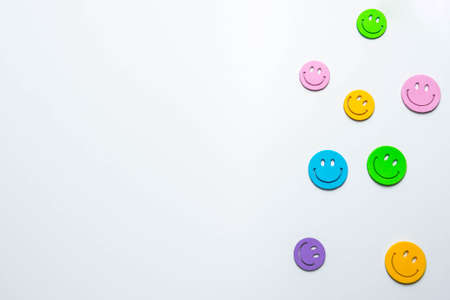 Multicolored icons of smiling emoticons on white paperの写真素材