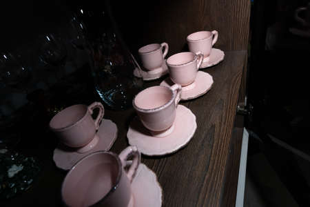 Household items. Pink vintage cups on a sideboard shelf.の写真素材