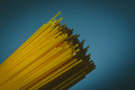 Durum wheat spaghetti on a dark blue background. Raw pasta.の写真素材