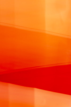 Bright red orange abstract soft blurred vertical background. Backdrop divided into sections by oblique lines with a gradient.の写真素材