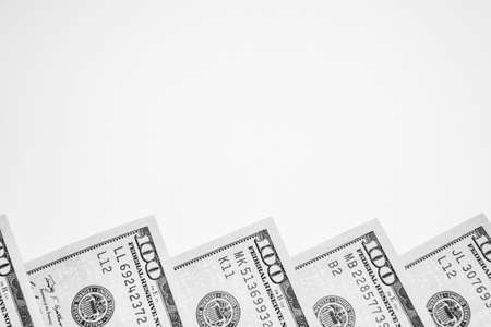 Corners of one hundred dollar bills on a white background. Monochrome image. Business theme. Place...