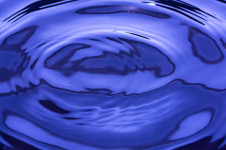 Beautiful liquid blue background with glitter. Small circular water waves. backdrop.の写真素材