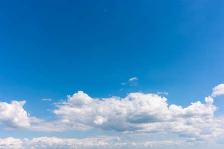 Low floating white clouds in a clear blue sky. Place to write text.の写真素材
