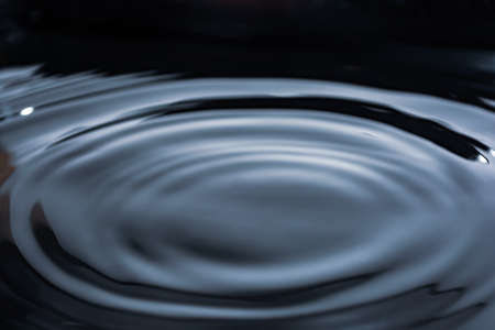 Circles on dark water. Shiny surface. liquid background banner. view from above. Provides space for text.の写真素材