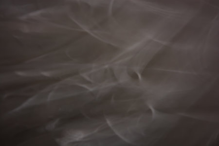 Dark gray background with white blurry waves. soft blur. smoke abstraction. backdropの写真素材