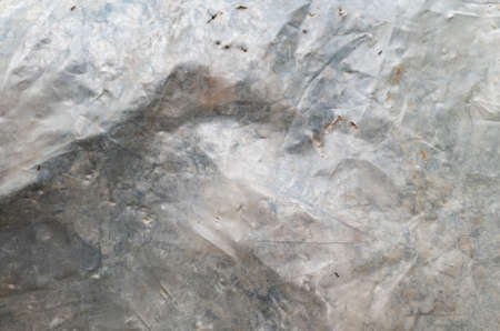 Background from old crumpled dirty polyethylene. Gray streaks and spots. backdrop