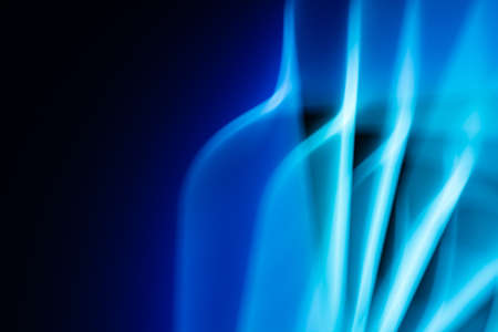 Light from a led lamp in motion in the dark. technology theme. Abstract banner in blue colors. back.の写真素材