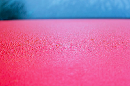 Water drops close-up on the hood of a red car. selective focus.の写真素材