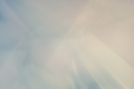 The image presents an abstract background with a smooth gradient that fades from light blue shades to soft pastel colors. This creates a calm and soothing visual effect.の写真素材