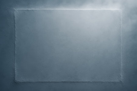 A textured concrete surface features a defined rectangle in the center with soft light shining from above, creating a minimalist backdrop for design needs.の素材