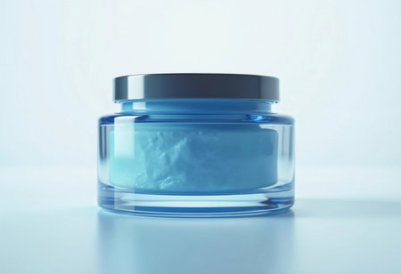 A gorgeous blue cream jar with a sleek silver lid sits on a minimalist backdrop, showcasing its smooth, rich texture.の素材