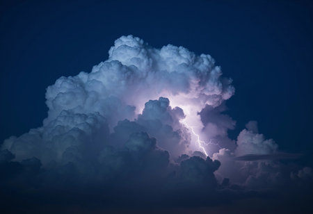 Flashes of lightning pierce through towering clouds at night, illuminating the dark sky with a brilliant glow. The turbulent atmosphere suggests an impending thunderstorm filled with energy.の素材