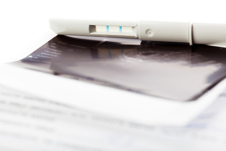 positive pregnancy test and ultrasound of baby in mother's womb close-upの写真素材