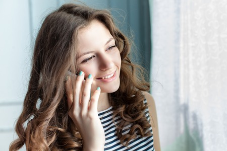 Young woman is speaking on the mobile phone. Studio shot