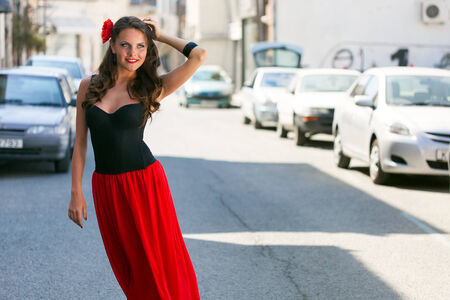 Smiling spanish woman in black dress is posing in the townの写真素材
