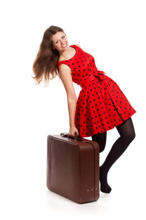 A smiling woman is holding a suitcase. Isolated on a white backgroundの写真素材