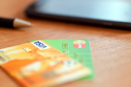 RUSSIA, OREL -  NOVEMBER 2015: Two credit cards of Mastercard and Visa, pen and phone on the table. Soft focusのeditorial素材