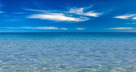 Crystal clear sea and blue sky with cloudsの写真素材