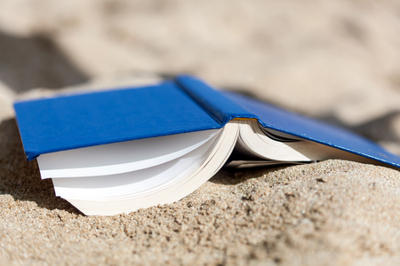 opened book on sand at sea beachの写真素材