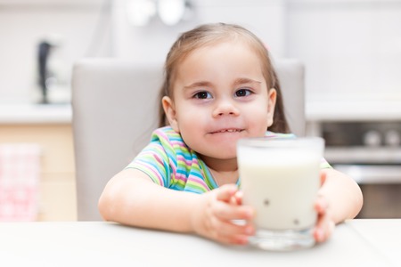 Little girl having breakfast with milk kitchenの写真素材