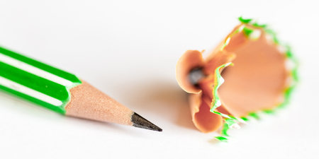 Green pencil and shavings on white paperの写真素材