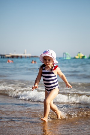 cute little girl playing on sea beachの写真素材
