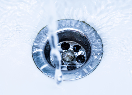 Stream of clean water flowing into the sink.の写真素材