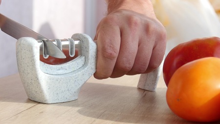 Manual sharpening of a knife in a special sharpener