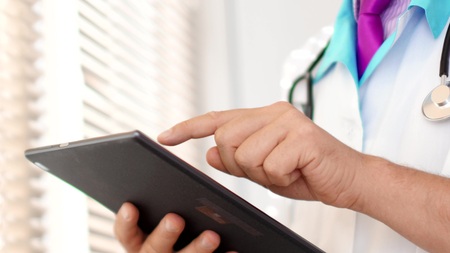 Medical doctor touching digital tablet computer
