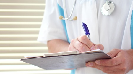 Male doctor writing medical prescription or certificateの写真素材
