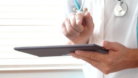Male doctor working with a modern touchscreen tablet computer