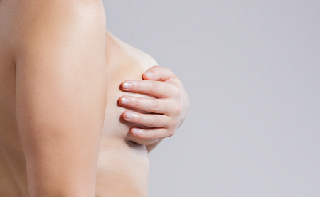 Woman covers her breasts with her palm. Concept of woman health.の写真素材