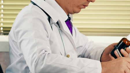 Male doctor writing rx prescriptionの写真素材