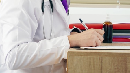 Close-up of writing medical rx prescription. Doctor working in his cabinetの写真素材