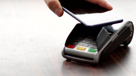 Person using contactless payment with smartphone.の写真素材