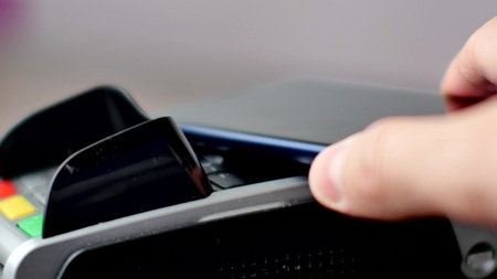 Person using contactless payment with smartphone.の写真素材