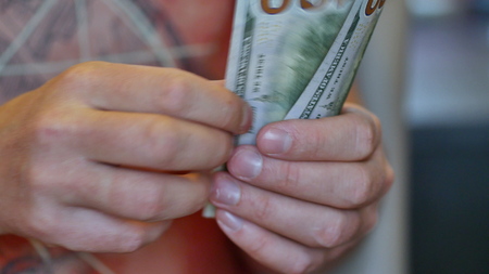 View of a man counting many american 100 bills