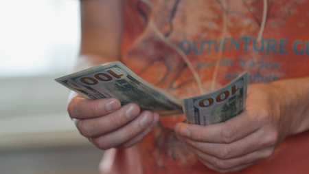 View of a man counting many american 100 bills