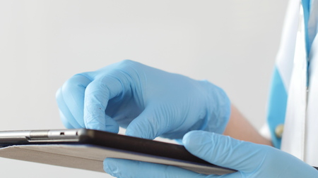 Doctors hands typing on modern digital tablet. Concept of modern healthcareの写真素材