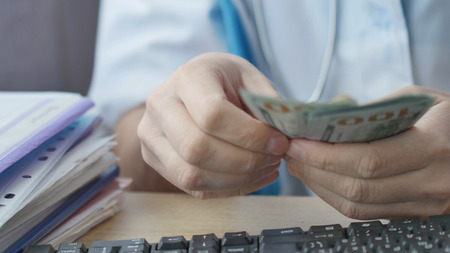 Corrupted medical doctor counting money.の写真素材